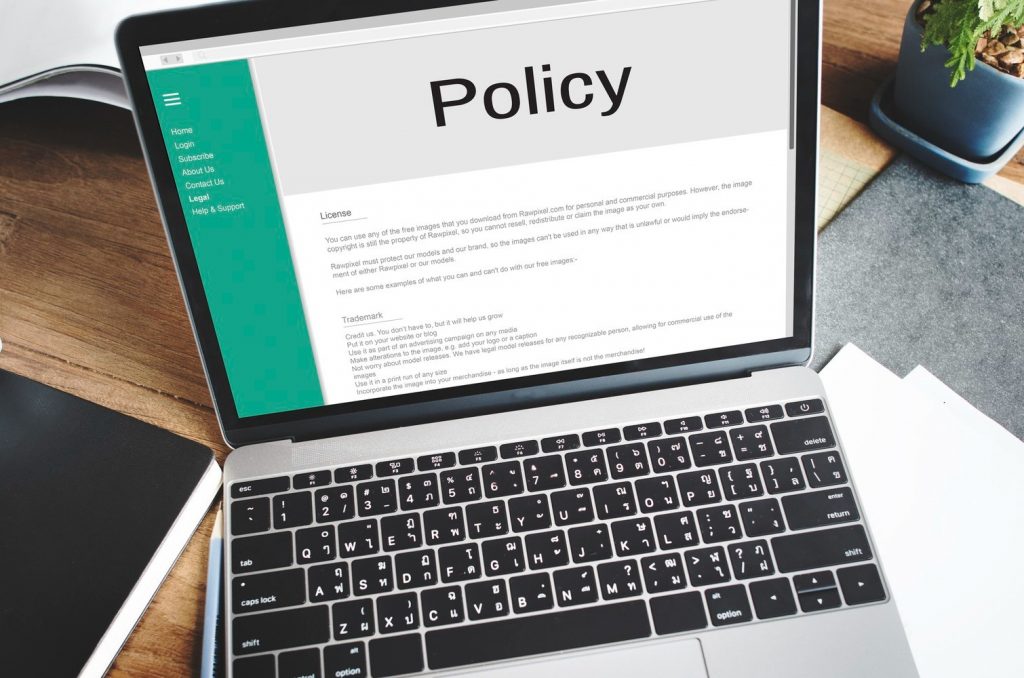 A laptop on a desk with the word Policy displayed on the screen. A Virtual Assistant can assist with GDPR compliance and policies.